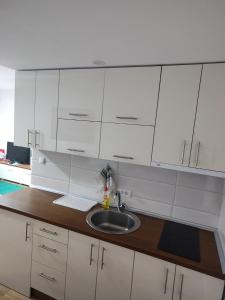 a kitchen with white cabinets and a sink at APARTMANI PORTA INFINITAS centar in Vrnjačka Banja +266 photos