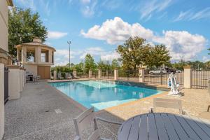 a swimming pool with a table and chairs next to a fence at Best Western Plus North Houston Inn & Suites in Houston