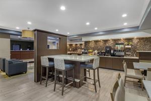 a lobby with a table and chairs and a kitchen at Best Western Plus North Houston Inn & Suites in Houston