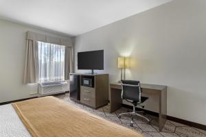 a room with a desk and a television and a chair at Best Western Plus North Houston Inn & Suites in Houston