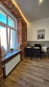 a living room with two tables and a brick wall at Apart Complex Green Rewolucji 27 in Łódź