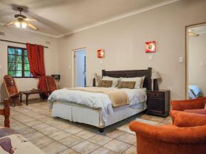 a bedroom with a large bed and a chair at Parkers Cottages in St Lucia +46 photos