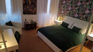 a bedroom with a large bed with a green blanket at Bilocale in Palazzo del XVI Secolo in Campobasso
