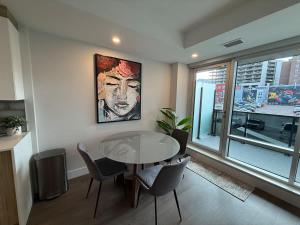 Un comedor con mesa y sillas y una ventana. en Spotless vibrant & modern 1 BR with 6 appliances, en Halifax