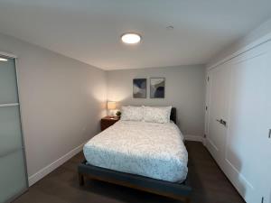 Un dormitorio con una cama en una habitación blanca. en Spotless vibrant & modern 1 BR with 6 appliances, en Halifax