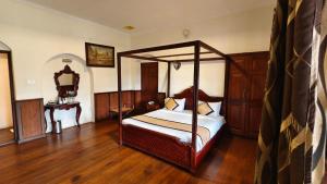 a bedroom with a canopy bed and a wooden floor at Yantra Resort, Ooty in Ooty