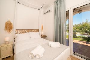 a bedroom with a bed with towels on it at Villa Calma by A&D Properties in Porto Rafti +77 photos