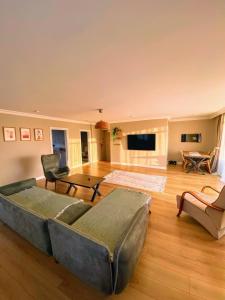 ein großes Wohnzimmer mit Sofa und TV in der Unterkunft Ahmed Teacher's hotel, including breakfast, closest to the airport in Arnavutköy + 25 Fotos