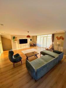 ein großes Wohnzimmer mit Couch und Tisch in der Unterkunft Ahmed Teacher's hotel, including breakfast, closest to the airport in Arnavutköy