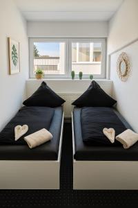 twee bedden in een kamer met twee ramen bij Business Apartments Augsburg mit WIFI, TV, Parken in Augsburg