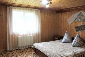 a bedroom with a bed and a window in a room at Сільська садиба in Yablunytsya