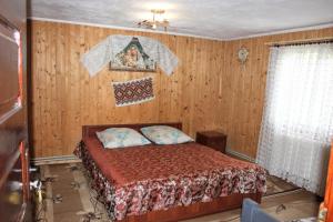 a bedroom with a bed and a painting on the wall at Сільська садиба in Yablunytsya