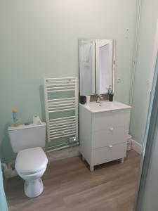 Cours la VilleにあるCOURS LA VILLEの白いトイレと洗面台のあるバスルーム