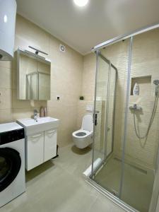a bathroom with a shower and a toilet and a sink at FILIP Lux Apartman sa garažom in Doboj