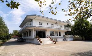a large white building with stairs and a balcony at Hotel Kastri in Nea Mesangala