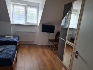 een kleine kamer met 2 bedden en een televisie bij Schöne Dachgeschoss Wohnung in Marl