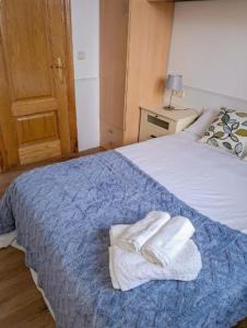 メリーデにあるCarmela Houseのベッドとタオル2枚のある寝室