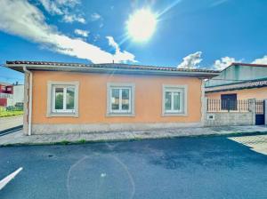 メリーデにあるCarmela Houseの空に太陽が輝く小さなオレンジ色の家