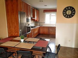 メリーデにあるCarmela Houseのテーブルと壁に時計があるキッチン +9枚の写真