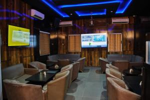 a dining room with tables and chairs and a tv at Masters Class Apartments in Mama