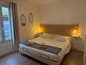 a bedroom with a large bed with two towels on it at Fenêtres sur Mer Arromanches in Arromanches-les-Bains