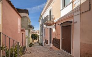 an alley in an old town with a door at Isola nel Parco Villas & Rooms in La Maddalena