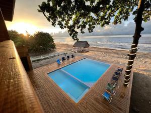 a swimming pool on a beach next to the ocean at Casa Playa Almendro, Tela, Honduras 