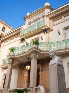 un bâtiment avec une statue devant lui dans l'établissement Villa Liberty, à Castellammare di Stabia