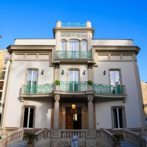 une maison blanche avec un balcon au-dessus dans l'établissement Villa Liberty, à Castellammare di Stabia
