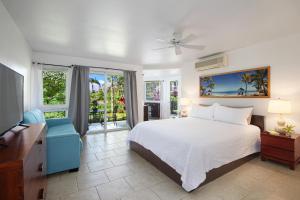 a bedroom with a white bed and a blue chair at Villas of Kamalii #35 in Princeville