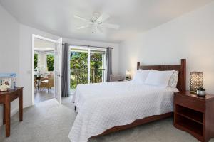a white bedroom with a bed and a table at Villas of Kamalii #35 in Princeville +4 photos