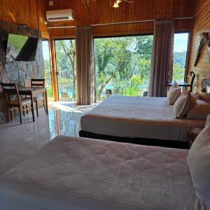 a bedroom with two beds and a table and chairs at Tupa Lodge in Puerto Iguazú