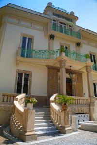 une grande maison avec des escaliers et un balcon dans l'établissement Villa Liberty, à Castellammare di Stabia