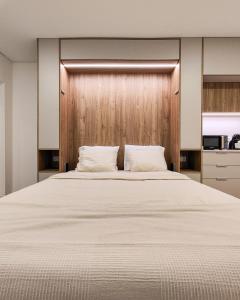 a bedroom with a large bed with a wooden headboard at Color Avenida T0 in Águeda