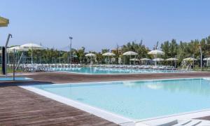 una gran piscina con sillas y sombrillas en Aurora - Casa Casoni, en Marcelli