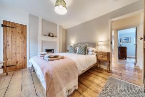 ein Schlafzimmer mit großem Bett und Holzboden in der Unterkunft Ivy Cottage in Thornham