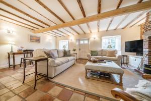ein Wohnzimmer mit Sofa und Tisch in der Unterkunft Ivy Cottage in Thornham