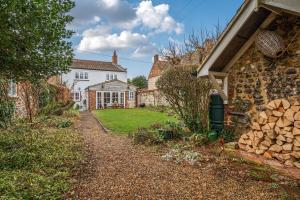 ein Haus mit einem Hof neben einem Gebäude in der Unterkunft Ivy Cottage in Thornham