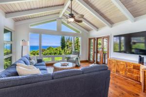 a living room with a blue couch and a large window at Wai Lani in Princeville +31 photos