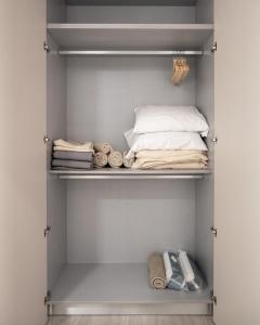 a closet with a bed and towels in it at Color Avenida T0 in Águeda