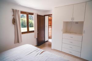 a white bedroom with a bed and a window at Check and Home - Chapa - 5 huéspedes con patio y parrilla in Chapadmalal