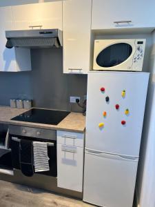 a kitchen with a white refrigerator and a microwave at 2 Bedroom Flat Sun in town Center Wellingborough in Wellingborough