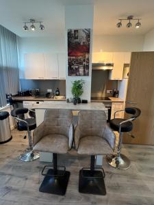 a kitchen with two bar stools and a counter at 2 Bedroom Flat Sun in town Center Wellingborough in Wellingborough