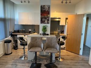 a kitchen with a counter and bar stools in it at 2 Bedroom Flat Sun in town Center Wellingborough in Wellingborough