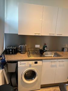 a kitchen with a washing machine and a sink at 2 Bedroom Flat Sun in town Center Wellingborough in Wellingborough +14 photos