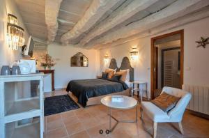 a bedroom with a bed and a table and a chair at Mas del Lum in Boussac