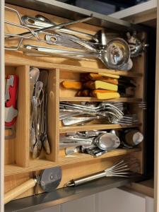 a wooden drawer filled with lots of silver utensils at La Casita de Community SurfHouse El Palmar in El Palmar
