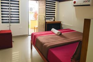 ein Schlafzimmer mit einem großen Bett mit einer roten Decke in der Unterkunft SAVITHRI Inn COTTAGE in Varkala + 32 Fotos