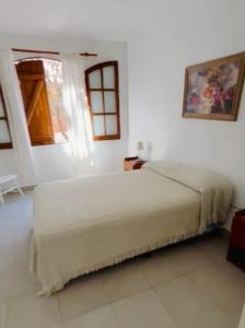 サンベルナルドにあるColonial suitesの白い部屋に大型ベッド1台が備わるベッドルーム1室が備わります。