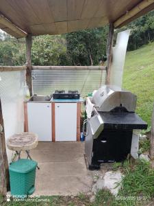 an outdoor kitchen with a grill and a stove at Cabaña el mirador del aguila in Quebradanegra
